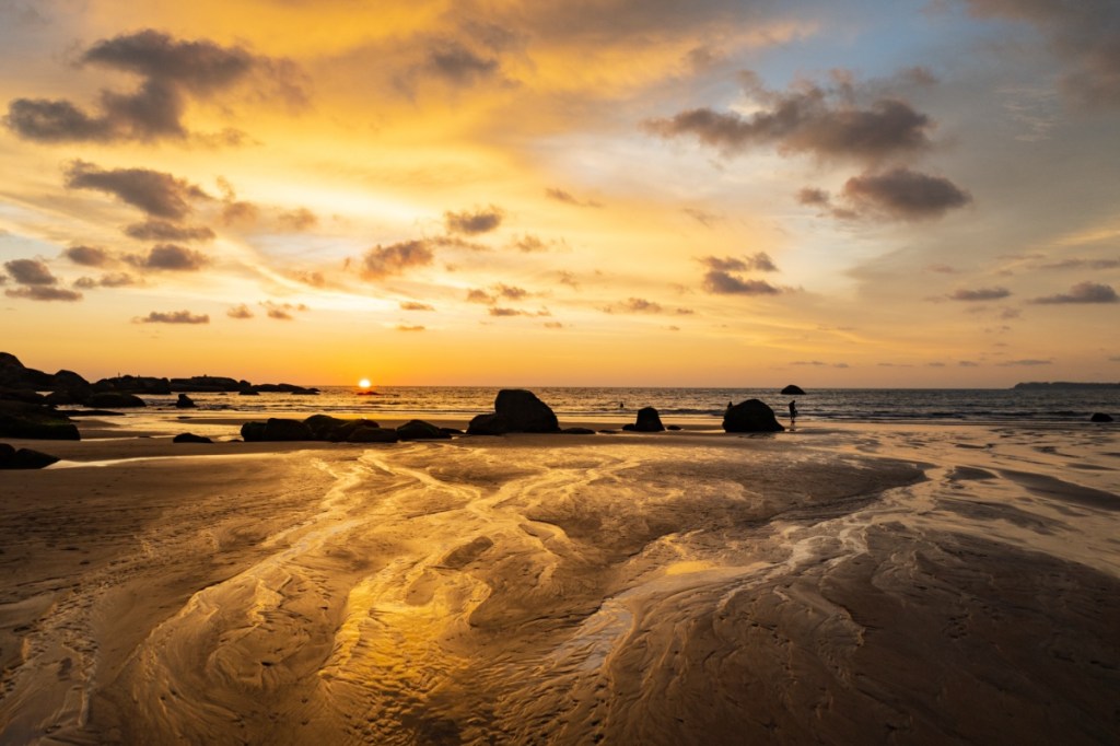 Ein Strand, in goldenes Abendlicht getaucht.