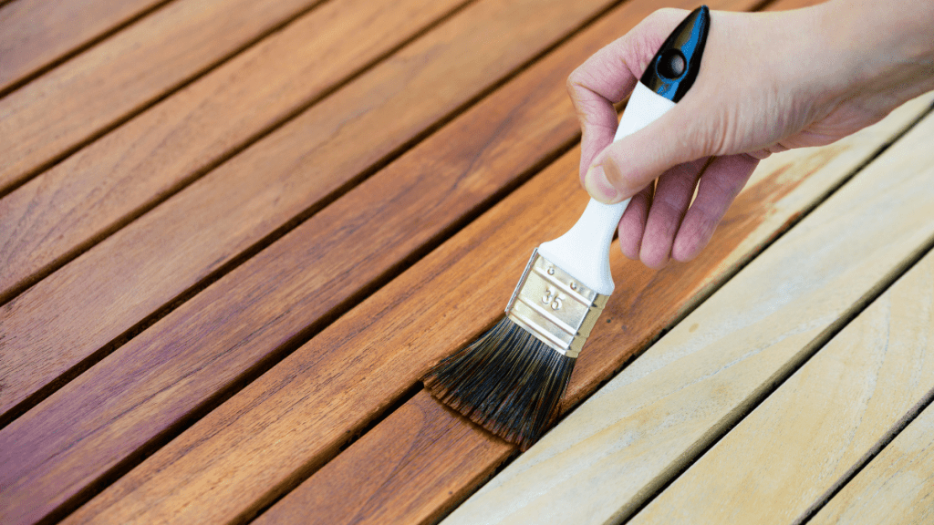 Eine Holzterrasse wird geölt.