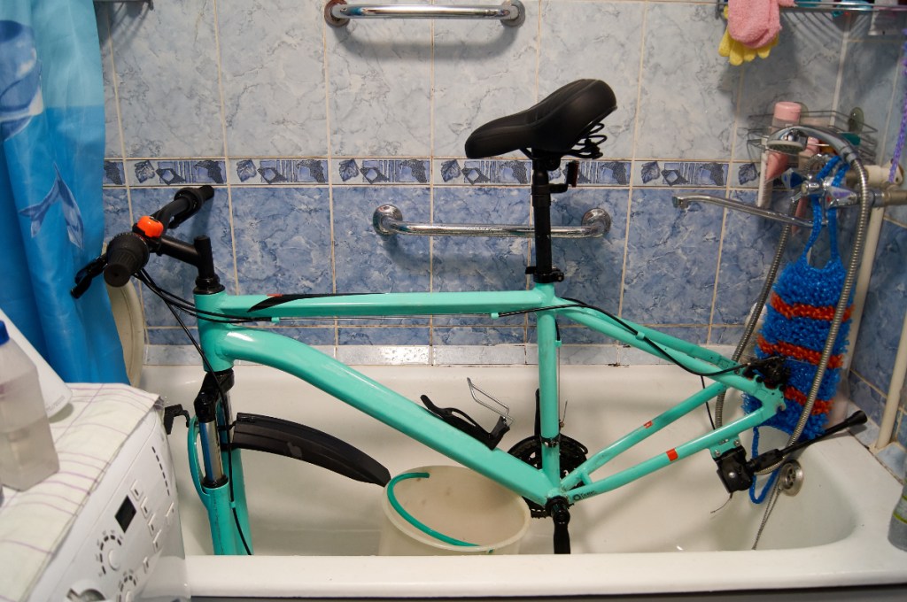 Ein Fahrrad steht in einer Badewanne und wird repariert und geputzt.