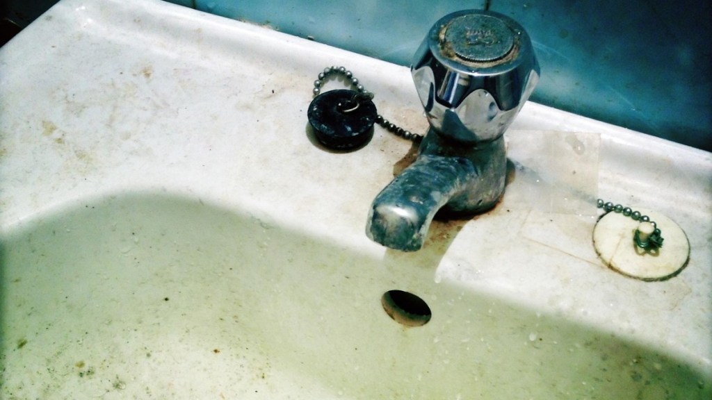 Armaturen reinigen: ein schmutziges Waschbecken mit einem dreckigen Wasserhahn