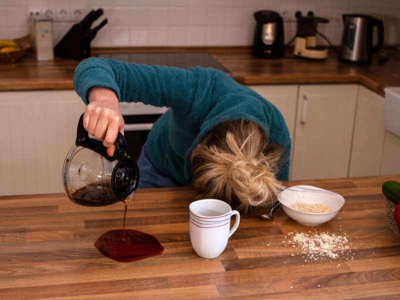 Ein lustiges Bild von einer Frau, die beim Kaffee-Einschenken einschläft.