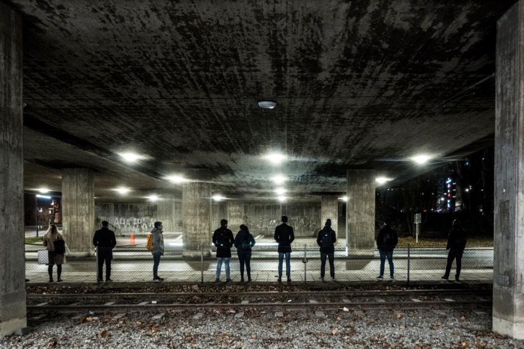 Menschen in Stockholm, Schweden, warten in der Dunkelheit auf den Bus.