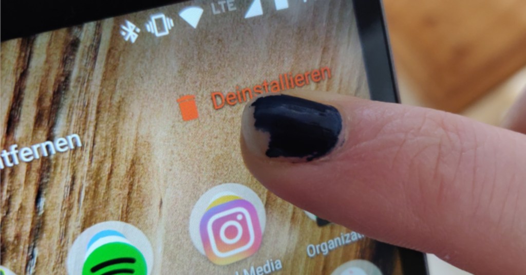 Eine Person mit abgeblättertem Nagellack tippt auf ihr Smartphone.