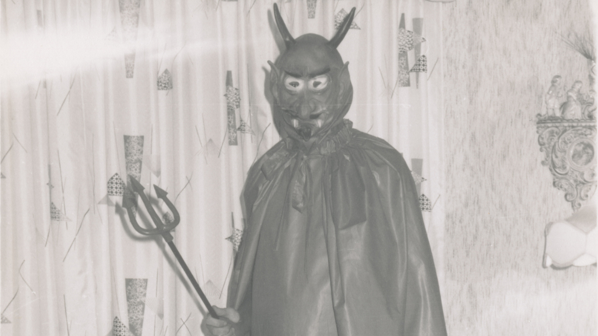 Ein historisches Foto von einem alten Halloween-KostÃ¼m, das einen Mann zeigt, der als Teufel verkleidet ist.