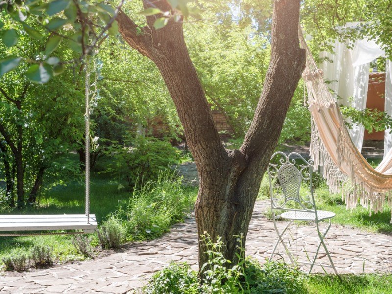 Eine Holzschaukel im Garten.