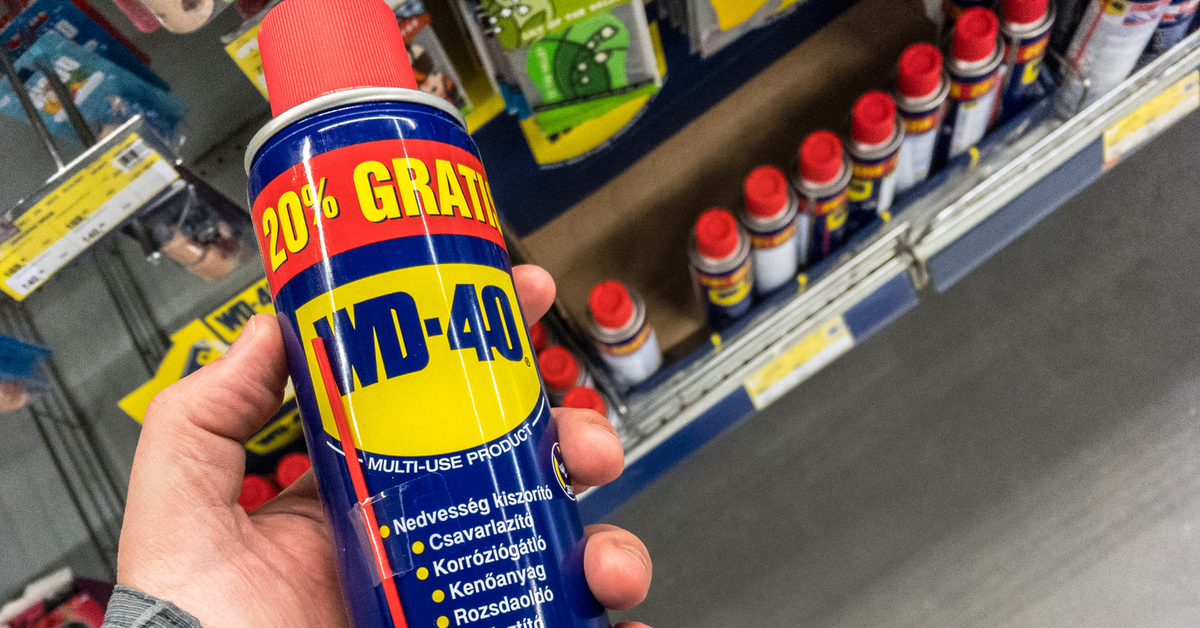 Jemand hält WD-40 in die Kamera. Im Hintergrund sieht man ein Regal mit weiteren Dosen des Kriechöls.