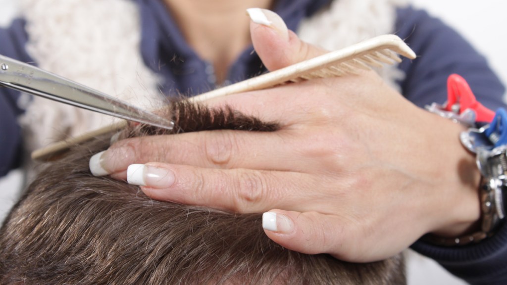 Einer Person werden die Haare kurz geschnitten.