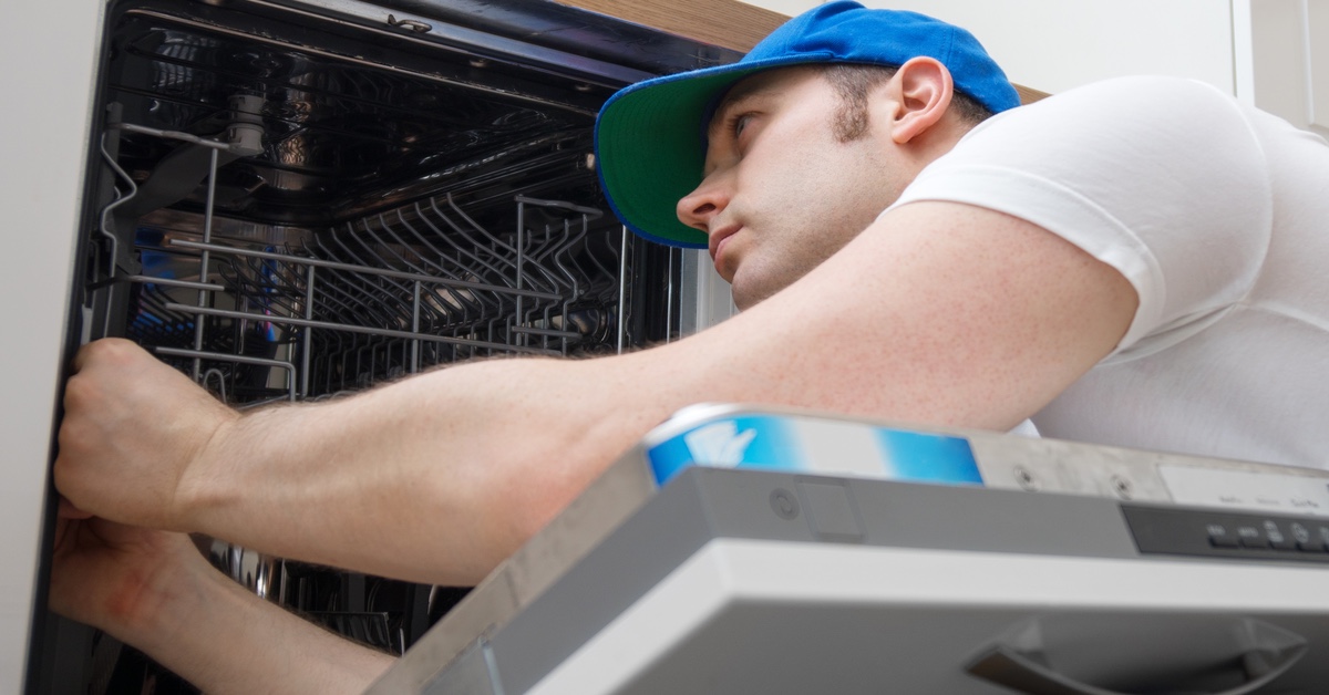 Handwerker repariert eine SpÃ¼lmaschine.