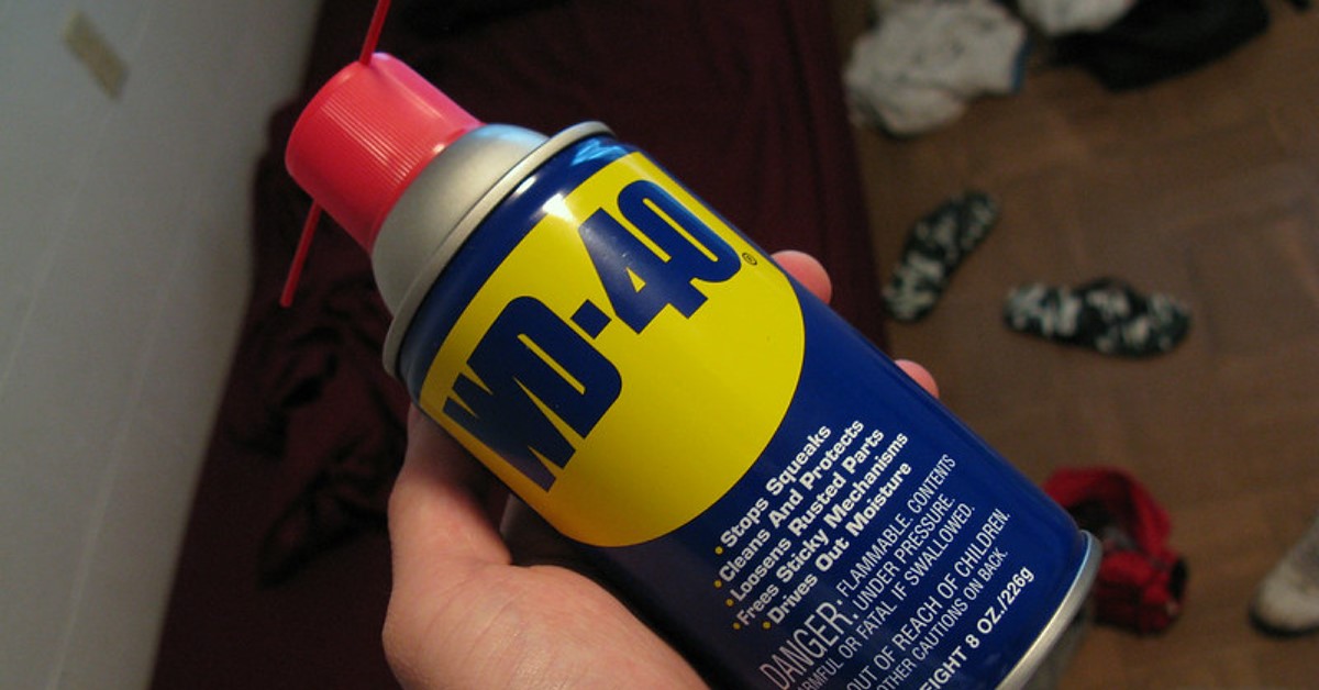Eine Hand hält WD-40 in die Kamera