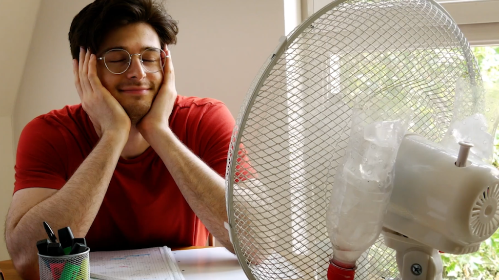 Ein Mann sitzt vor einem Ventilator.