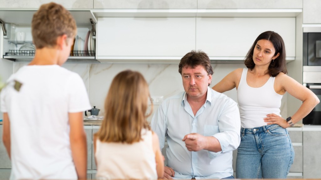 Vater redet mit erhobenem Zeigefinger auf Kinder ein