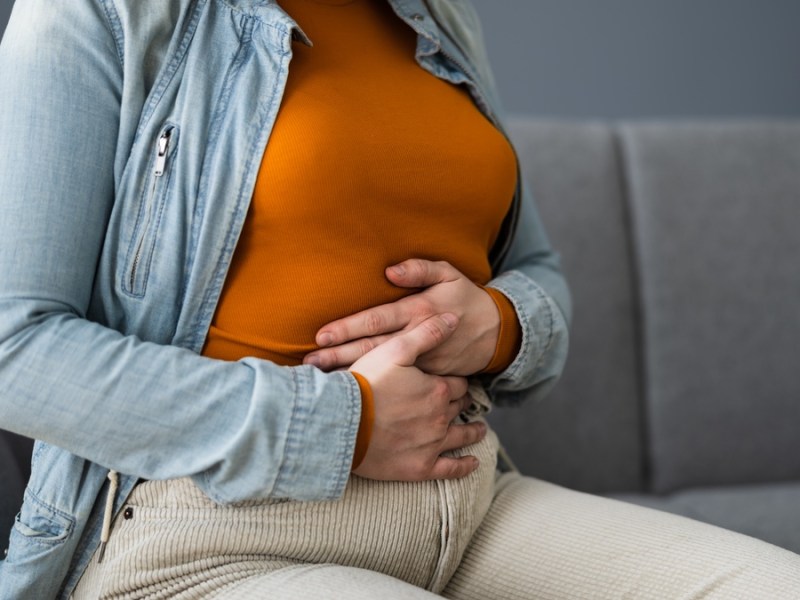 Eine Frau hält sich den Bauch.