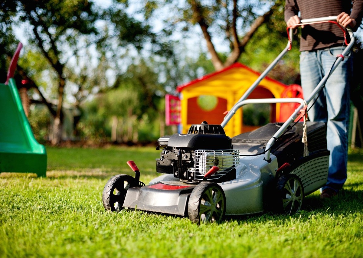 Ein Mann mäht den Rasen in seinem Garten.