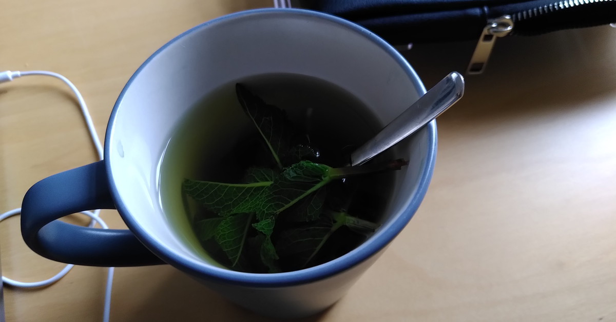 Teetasse mit eine Minze und einem Löffel darin