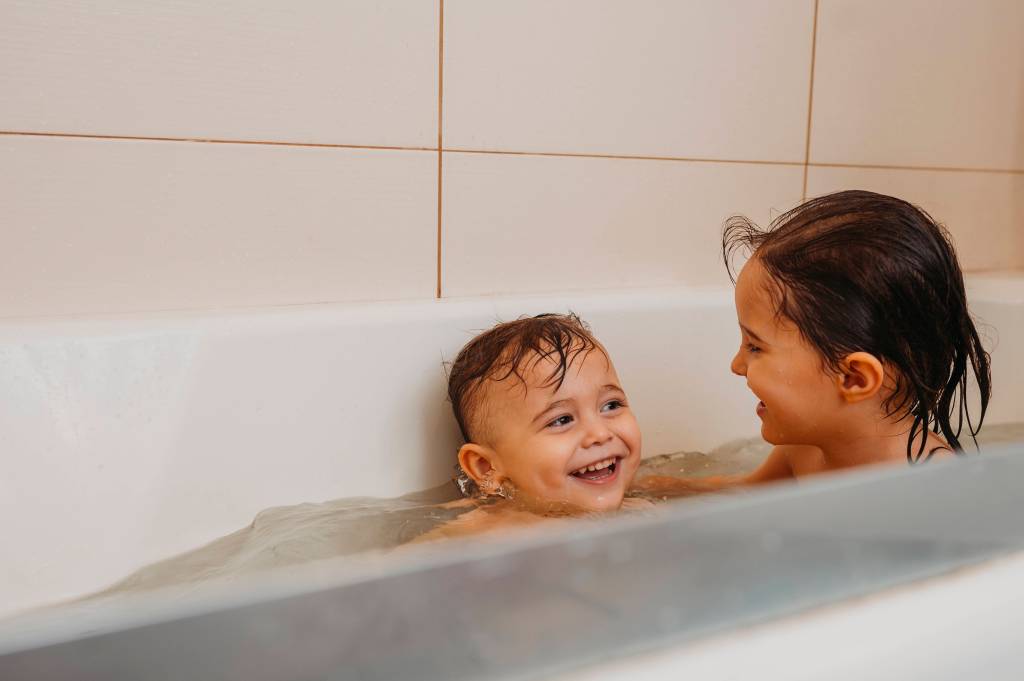 Kinder baden gemeinsam in der Badewanne.