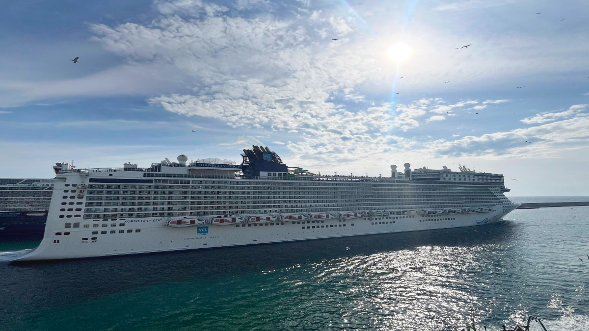 Ein Kreuzfahrtsschiff auf dem Wasser in der Sonne.