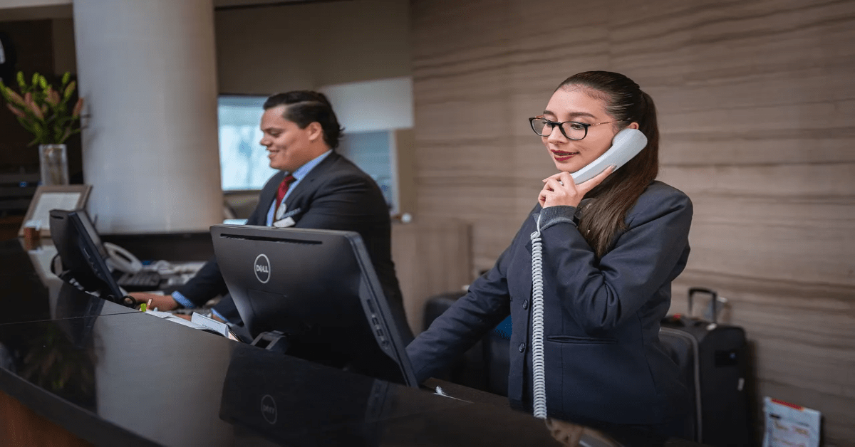 Hotelmitarbeiterin telefoniert in der Rezeption.