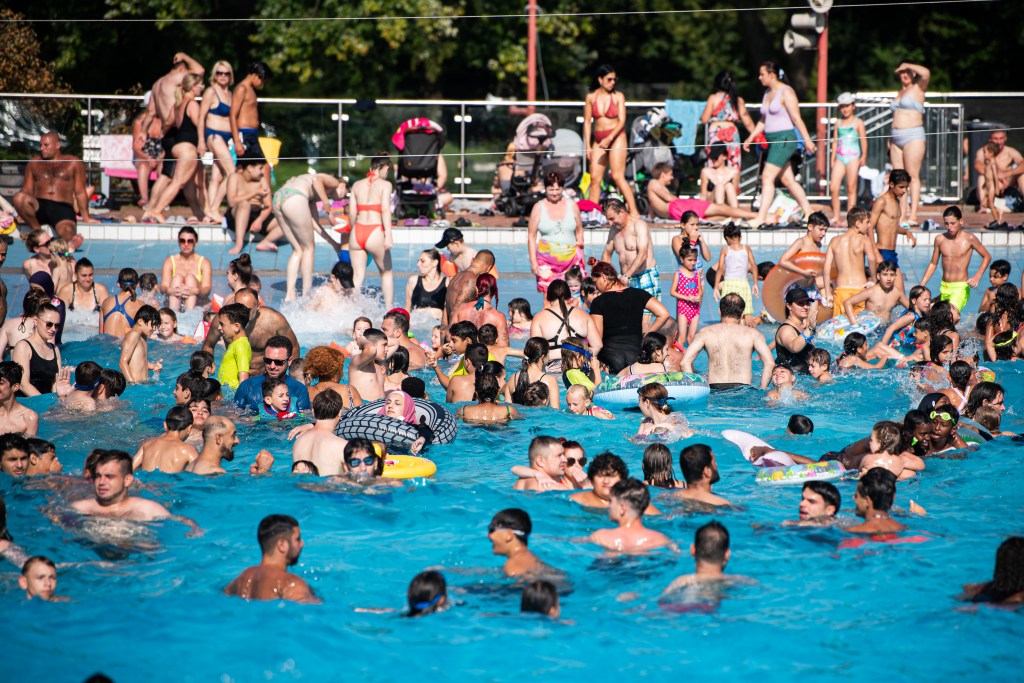 Ein überfülltes Schwimmbecken in einem Freibad.