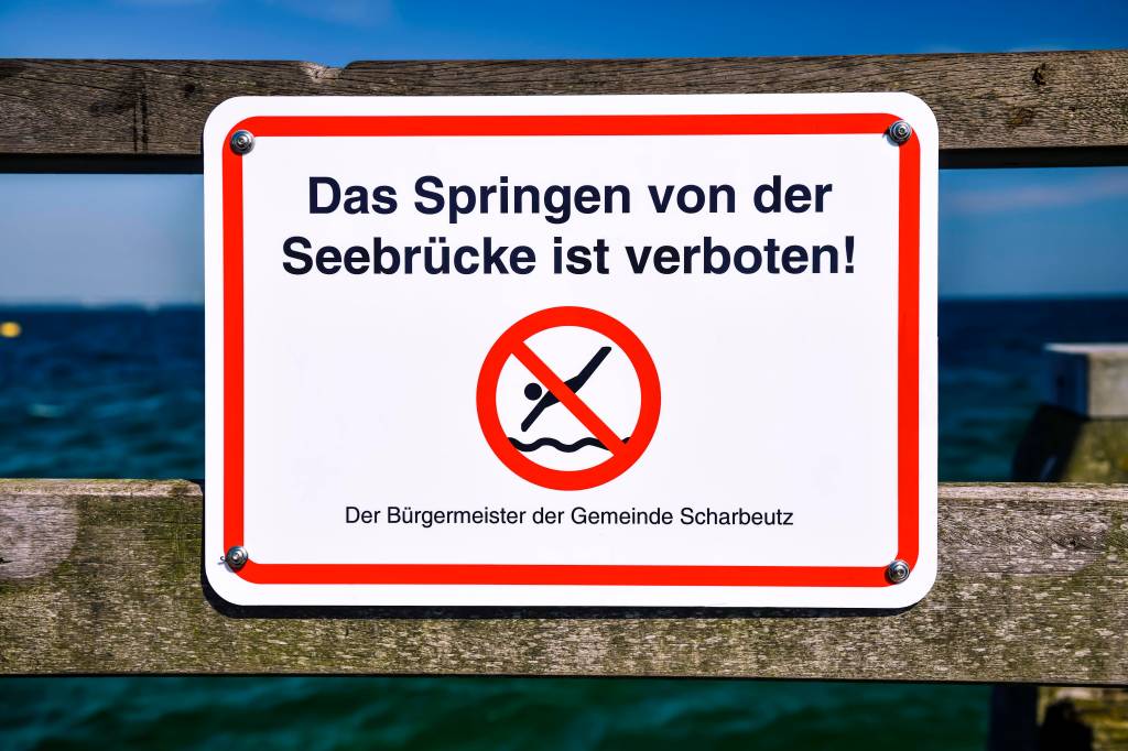 Ein Schild mit der Aufschrift: Das Springen von der Seebrücke ist verboten.