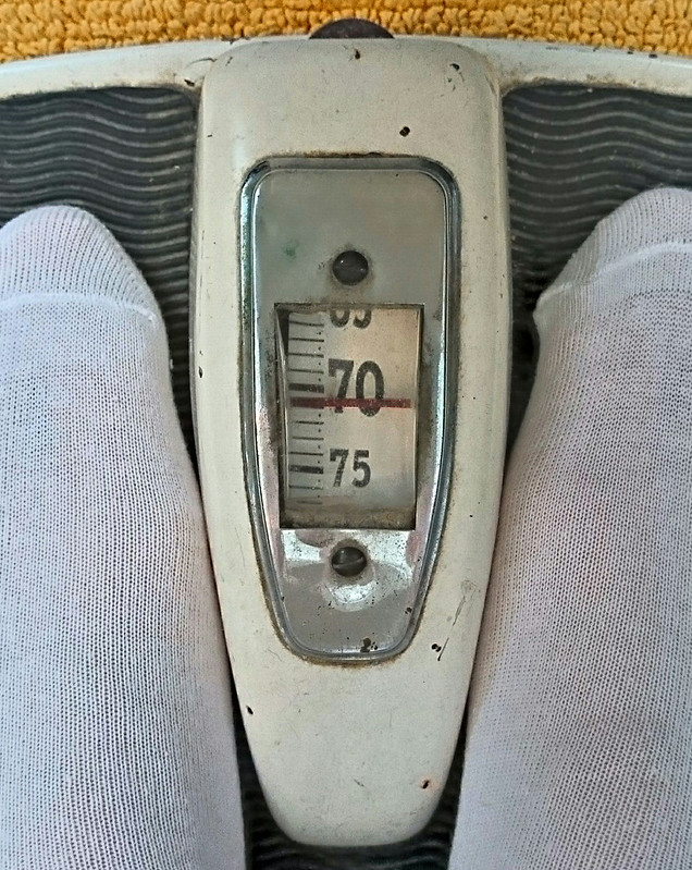 Füße auf einer alten Personenwaage