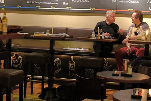 A couple chats in a french bistro