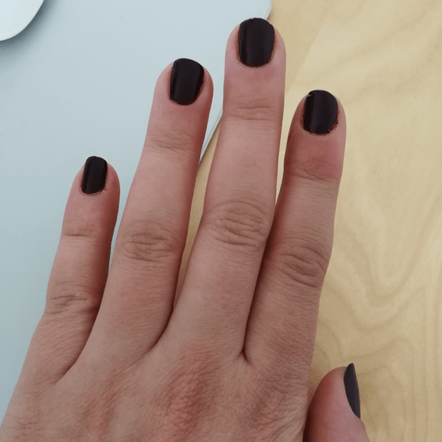 Hand mit schwarzem Nagellack