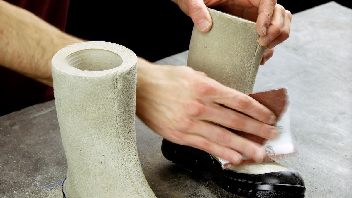 Beton-Stiefel werden mit Schleifpapier abgeschliffen.