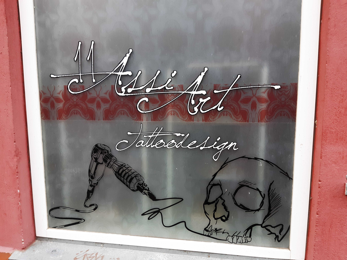 Ein Schaufenster eines Tattoo-Studios namens Assi-Art