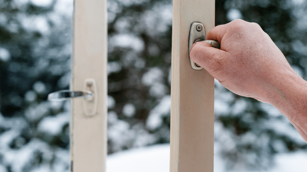 Hände öffnen Fenster im Schnee