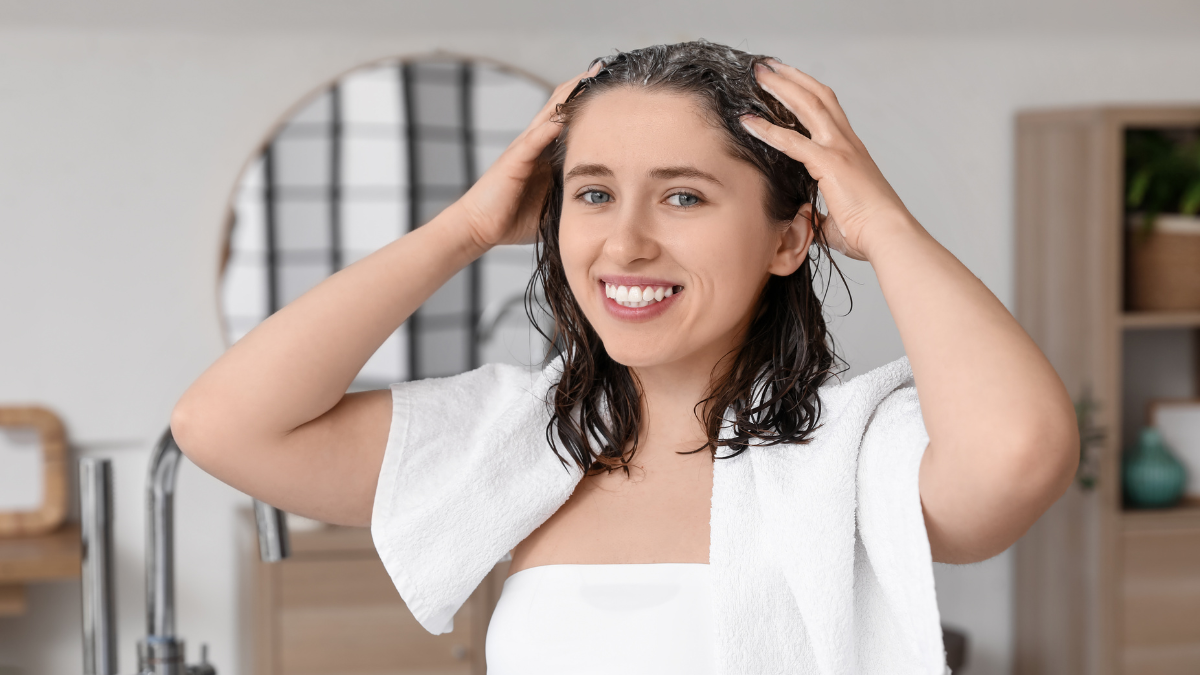 Eine Frau massiert Shampoo in ihre Haare.