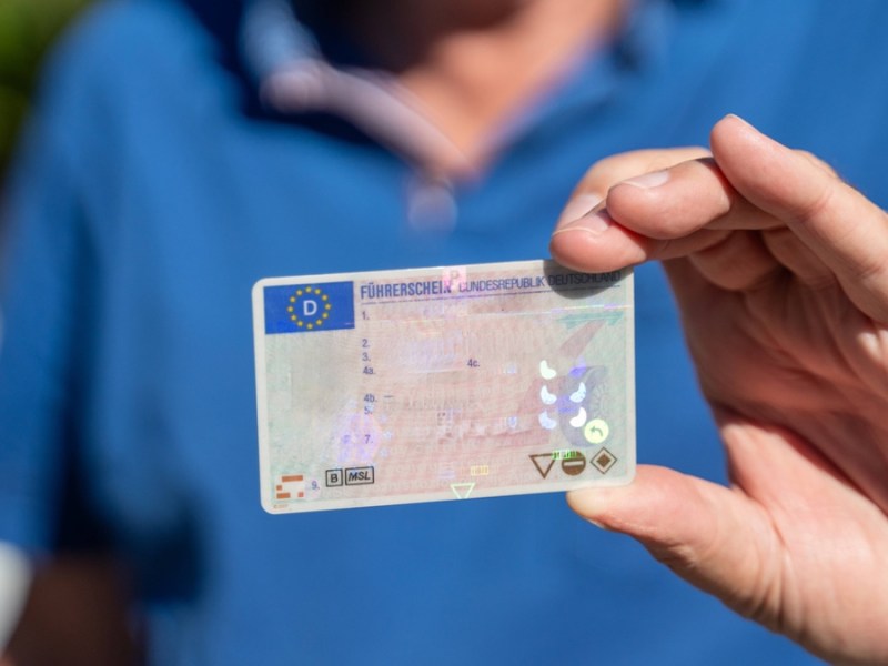 Jemand hält seinen Führerschein in der Hand.