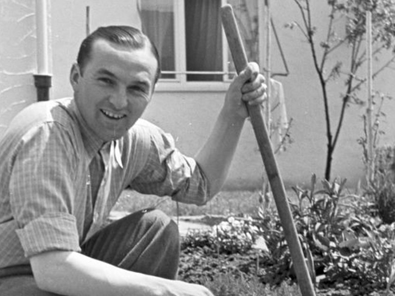 Ein Schwarz-weiß-Bild des Rennfahrers Hermann Lang bei der Gartenarbeit.