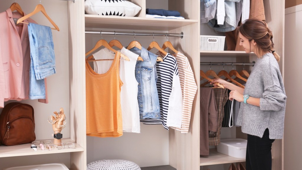 Frau steht vor einem Kleiderschrank.