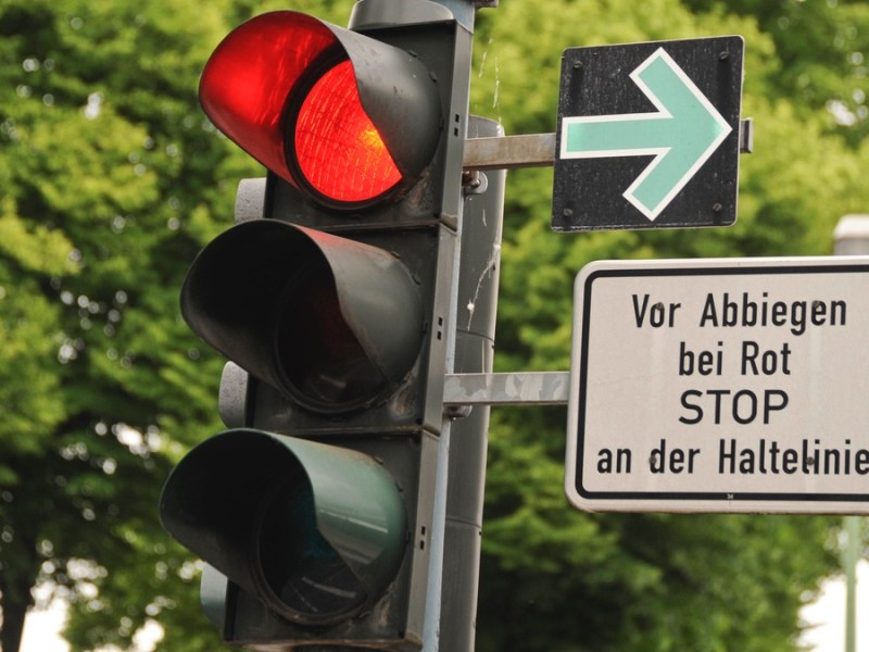 Grünpfeil an der Ampel mit Hinweisschild.
