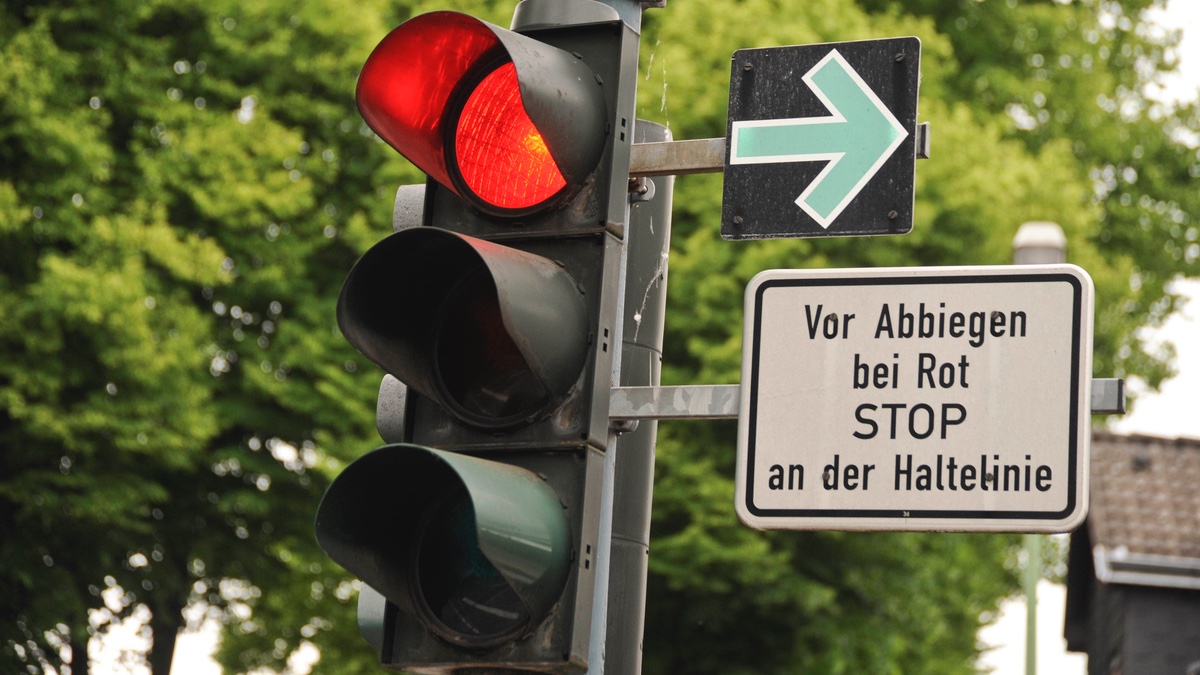 Grünpfeil an der Ampel mit Hinweisschild.