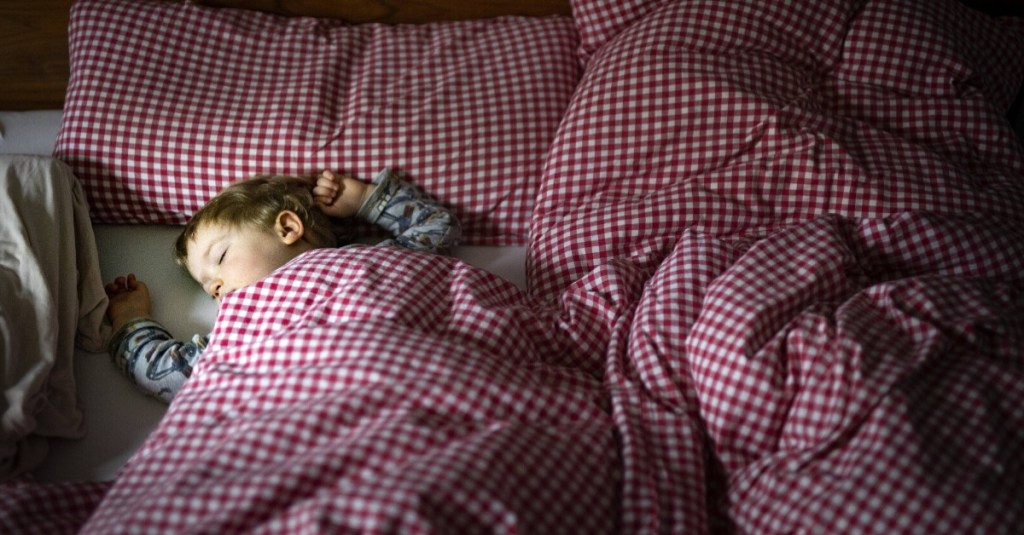 Kind liegt im Bett und Schläft