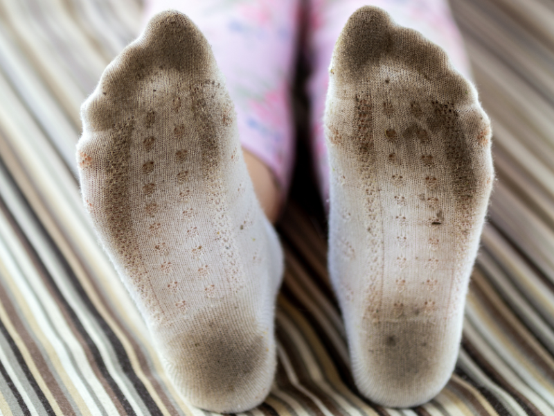 Dreckige Feiße Socken im Bett.