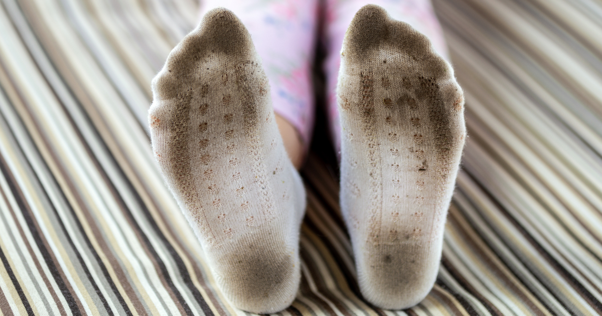 Dreckige Feiße Socken im Bett.