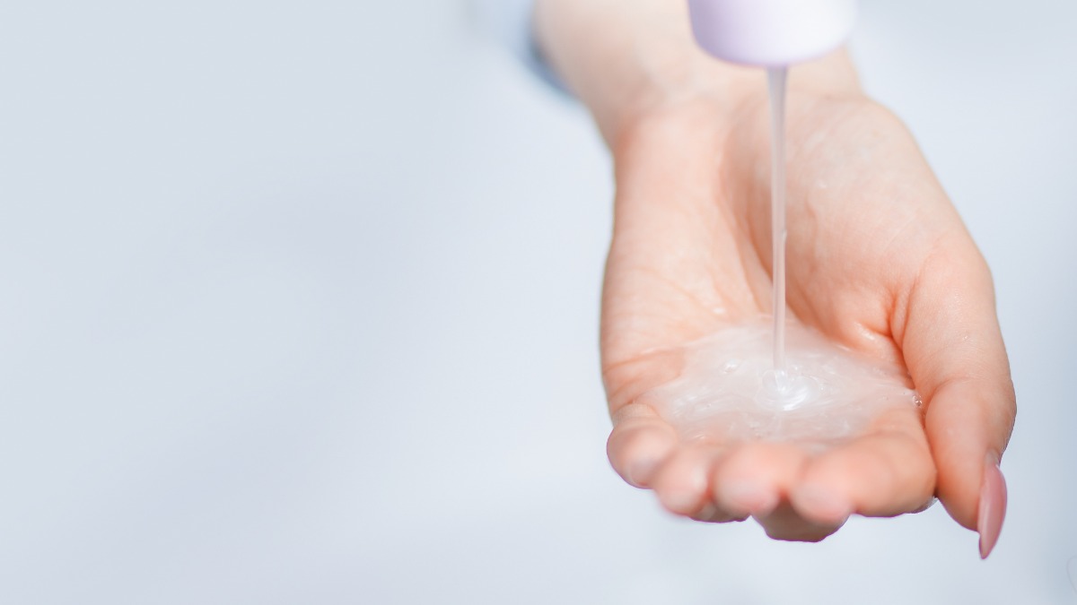 Haarshampoo wird aus der Flasche auf eine Hand gedrückt