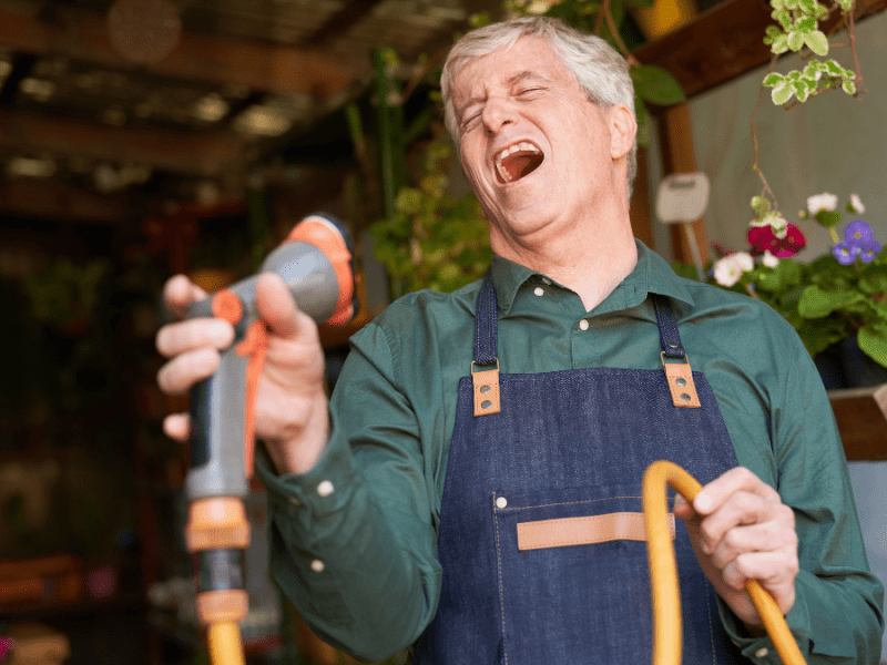 Ein Mann singt mit einem Gartenschlauch als Mikrofon.