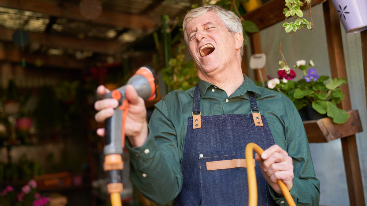 Ein Mann singt mit einem Gartenschlauch als Mikrofon.