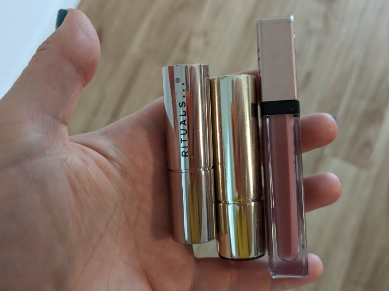 Mehrere Lippenstifte werden in die Kamera gehalten.