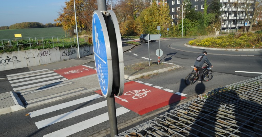 Fahrradfahrer fährt in einen Kreisverkehr ein.