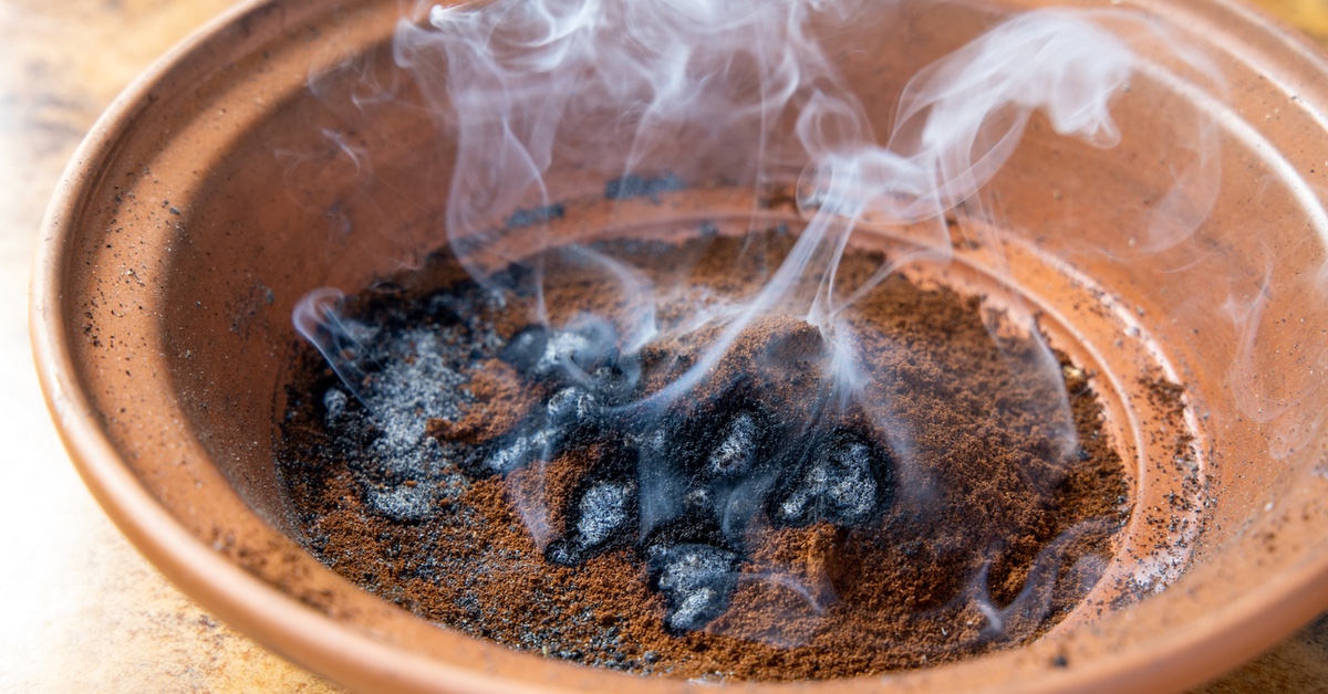 Qualmender Kaffeesatz in einem alten Tontopf.