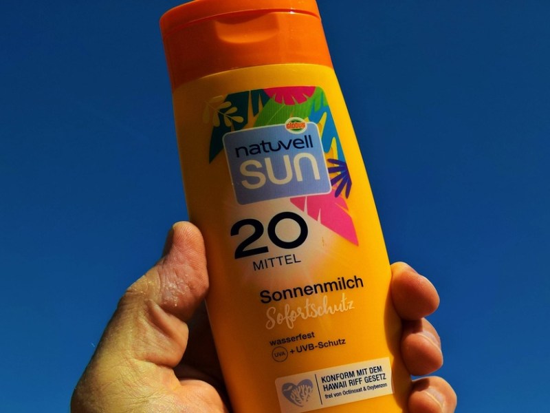 Sonnencreme in der Hand halten