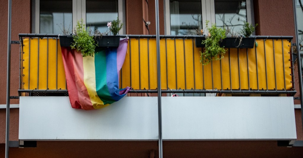 Eine Regenbogenflagge hängt an einem Balkon