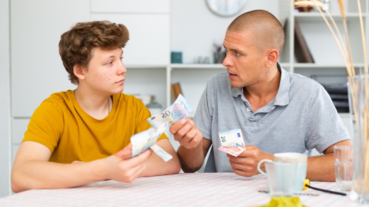 Teenager Sohn gibt seinem Vater Geld