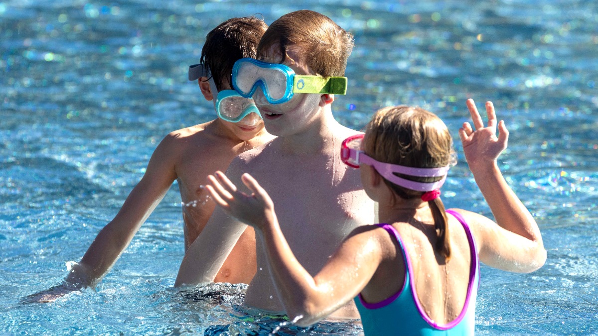 Kinder mit Taucherbrille im Freibad