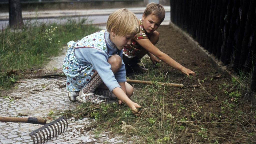Kinder helfen bei der Gartenarbeit.