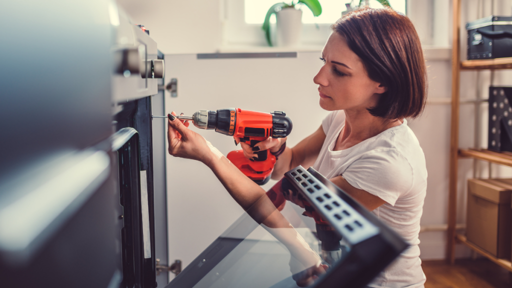 Eine Frau bedient in der Küche eine Bohrmaschine.